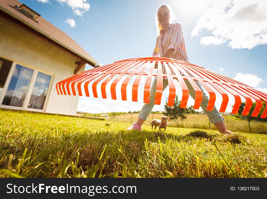 Unusual angle of woman raking leaves