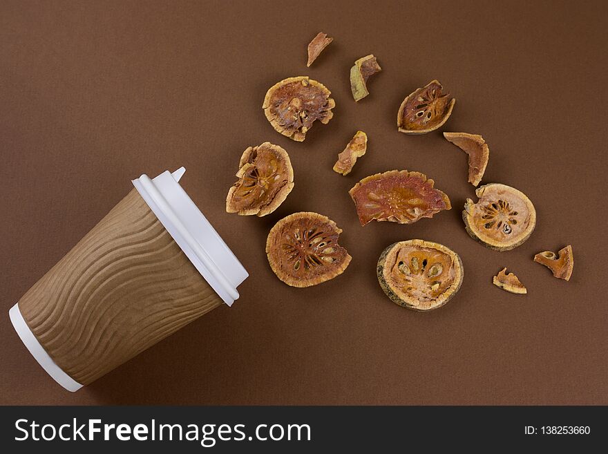 Top view matum take away tea and dried bael fruits flat lay on brown background