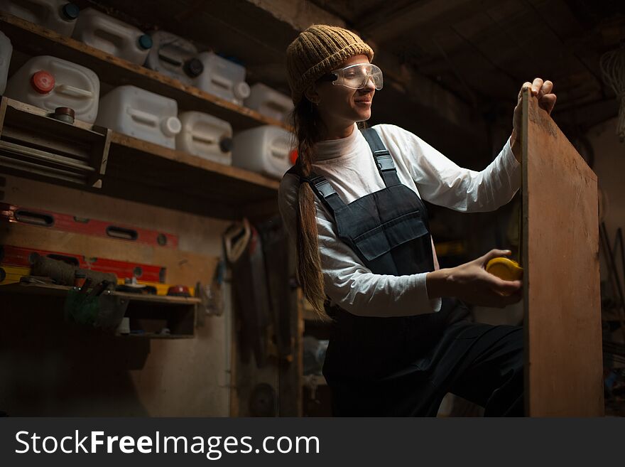 Portrait of smiling young girl carpenters in workshop room.
