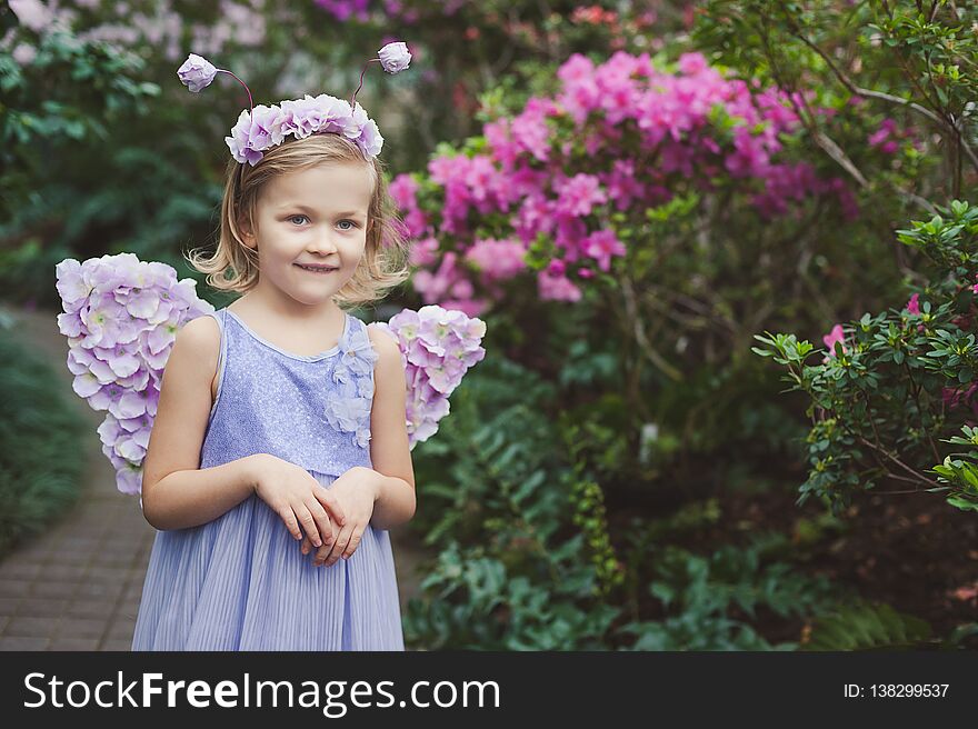 girl sniffing flowers of azaleas. flowering azaleas in the park