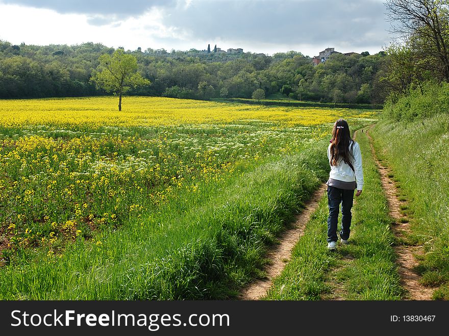 Young girl walking in meadow at spring time in Tuscany. Young girl walking in meadow at spring time in Tuscany