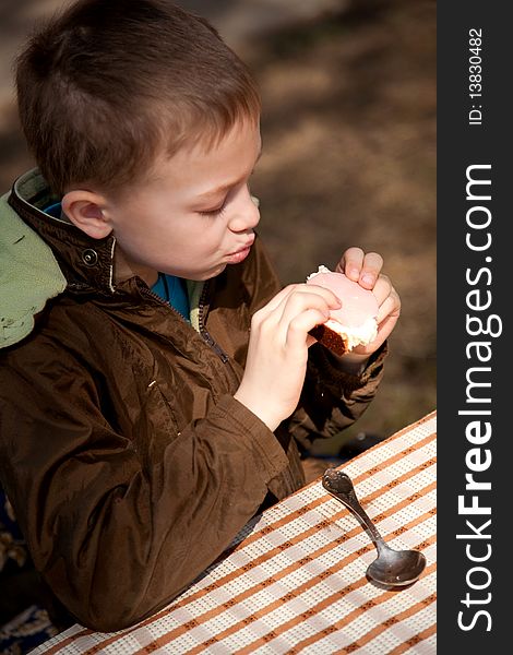 Boy eating his open sandwich and waiting his grandmother with soup. Boy eating his open sandwich and waiting his grandmother with soup