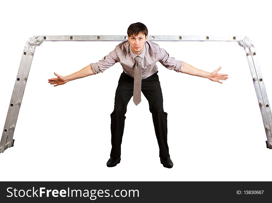 A handsome young businessman with rolled-up sleeves stands in ladder gates with spread hands as a goalkeeper. Horizontal shot. Isolated on white. A handsome young businessman with rolled-up sleeves stands in ladder gates with spread hands as a goalkeeper. Horizontal shot. Isolated on white.