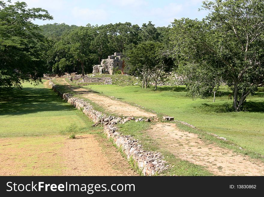 Mexican landscape with an old road running in the jungle with ruins af an ancient maya city. Mexican landscape with an old road running in the jungle with ruins af an ancient maya city