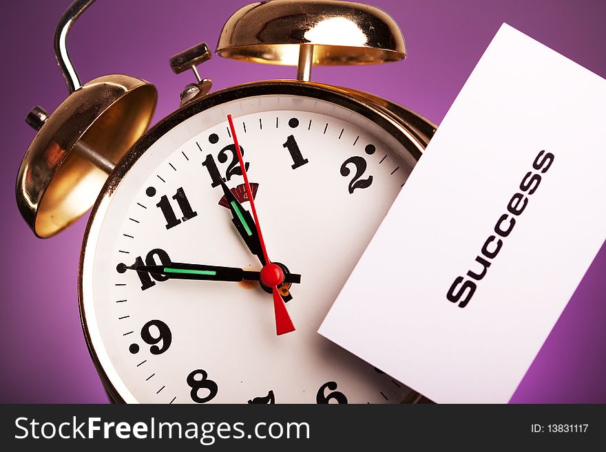 Clock with note shot in studio in violet background. Clock with note shot in studio in violet background