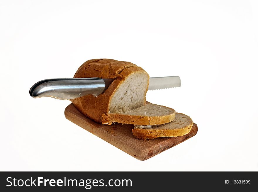 Cutting bread with the knife on the white background