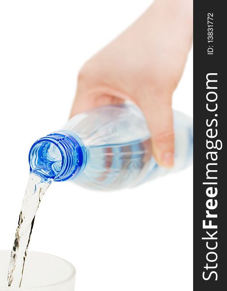 The girl pours water in a glass isolated over white