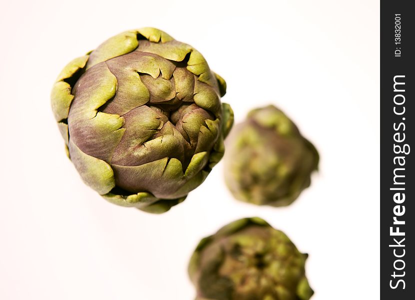 Three artichokes flying on a white background