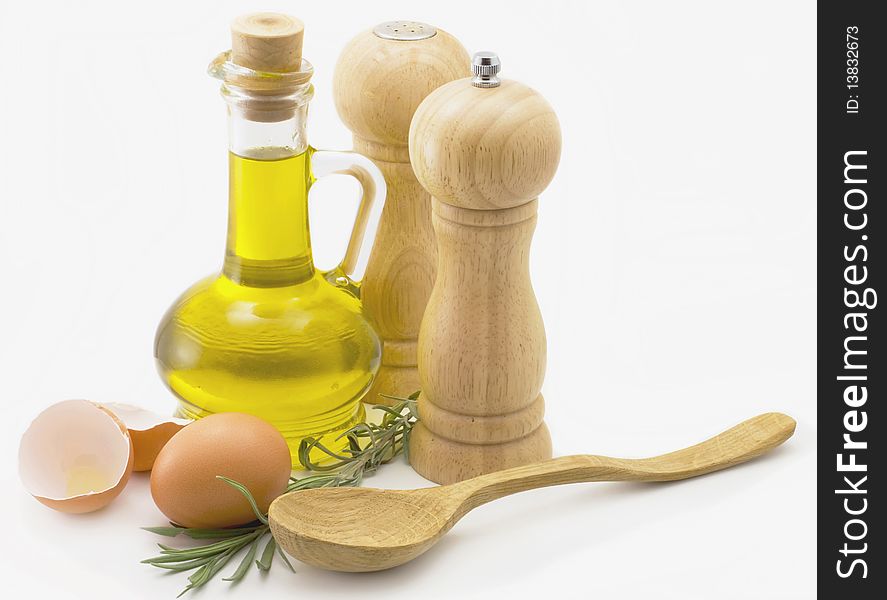 Olive oil, eggs, spices and a wooden spoon on a white background. Olive oil, eggs, spices and a wooden spoon on a white background