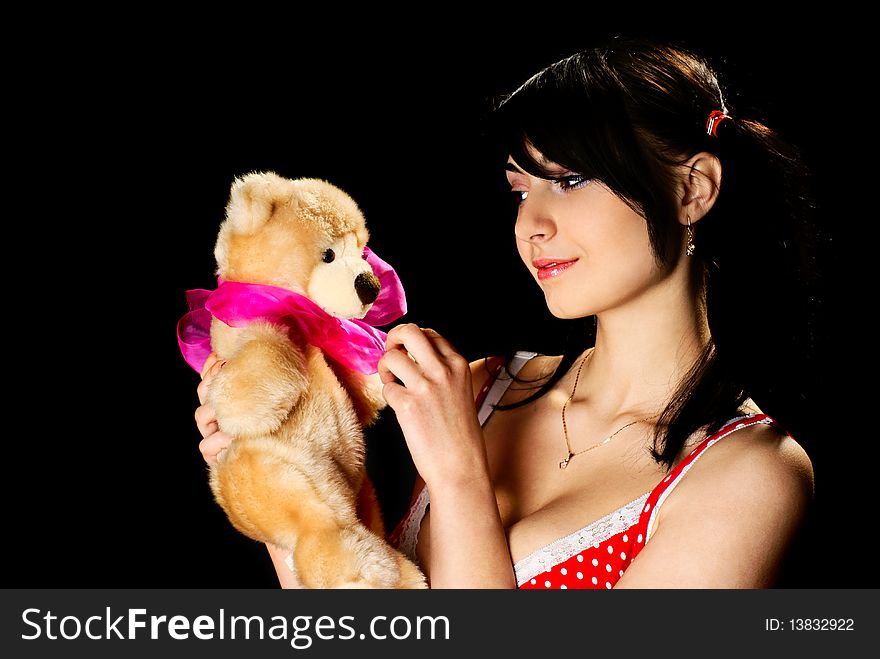 Young girl with plush toy. Black background. Studio shot. Young girl with plush toy. Black background. Studio shot.