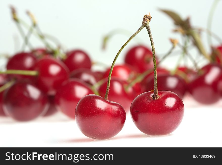 Two cherries on white background