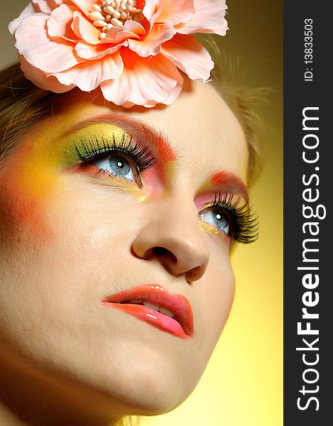 Concept of summer fashion woman with creative eye make-up in yellow and green tones sending kisses. copy-space