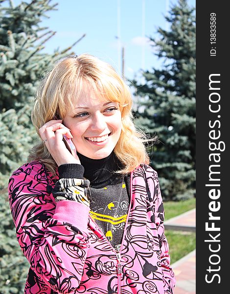 Young girls call by phone in a park