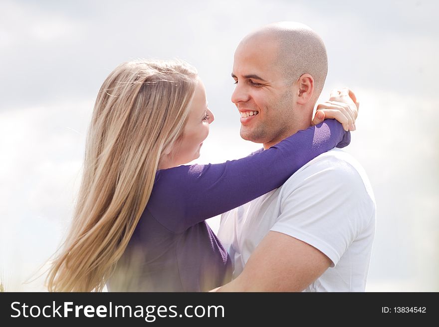 Loving Couple Standing Under The Blue Sky