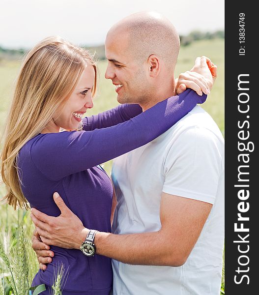 Men and woman hugging in the grass