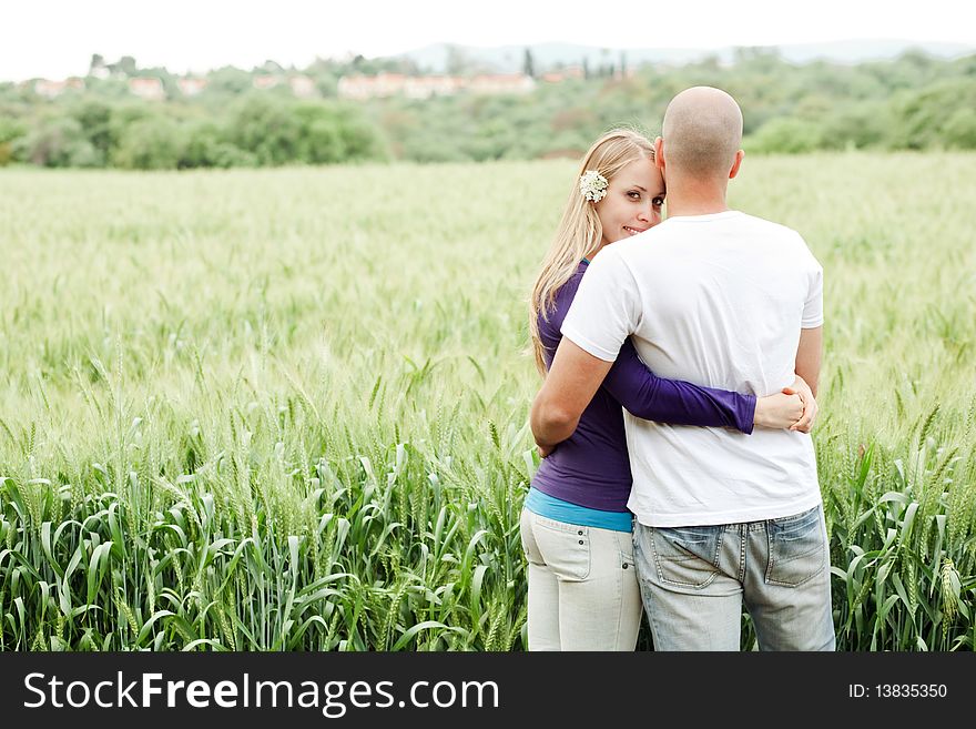 Lovers in park rear view, woman looking at camera in park