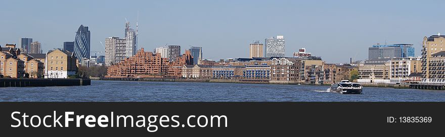 A boat on the thames with some of london's most famous buildings