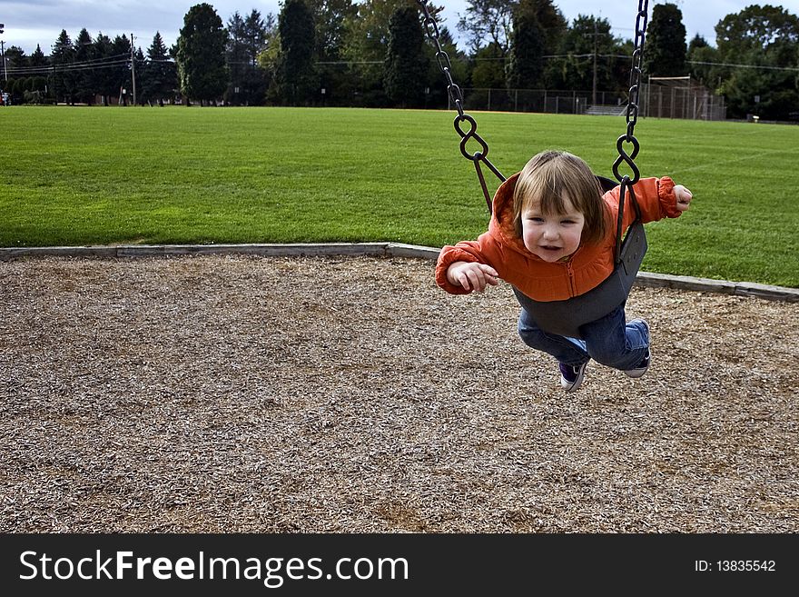 Child playing on a swing. Child playing on a swing