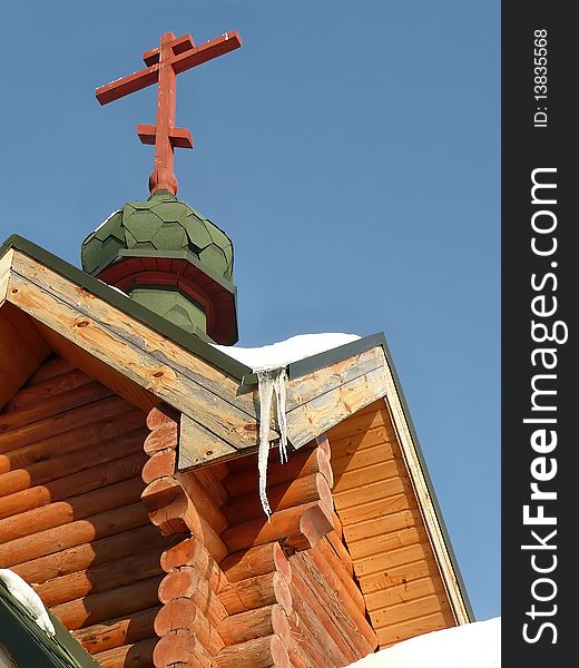 Fragment of a wooden chapel against the blue sky