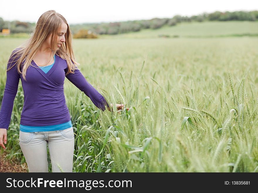 Portrait of lady walking between the grass in the field