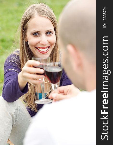 Young romantic couple celebrating with wine in picnic