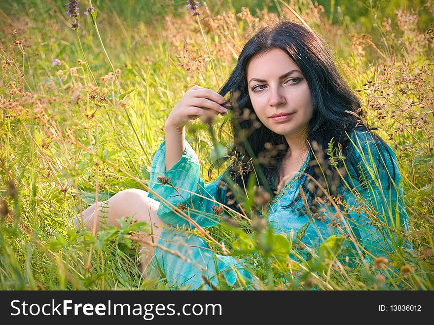 Young beautiful woman relaxing in field. Young beautiful woman relaxing in field.