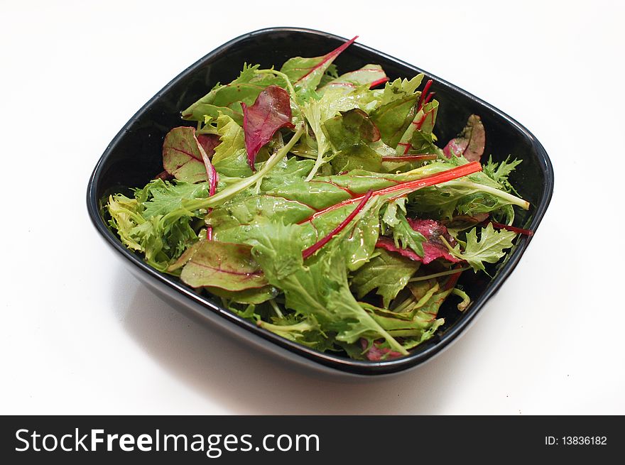 Salad with fresh rocket leaves in a black plate. Salad with fresh rocket leaves in a black plate