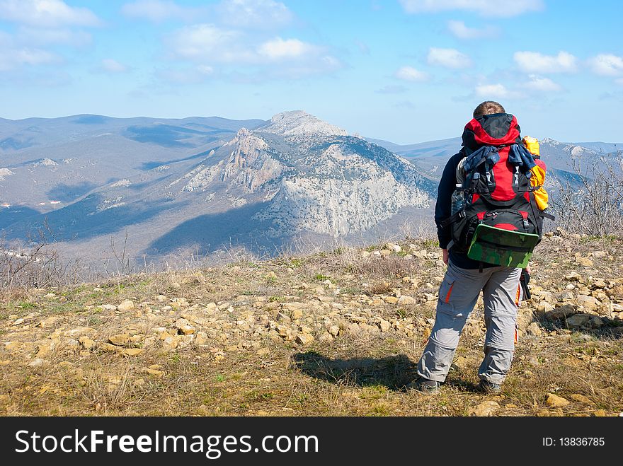 Hiker on a peak enjoys mountain landscape