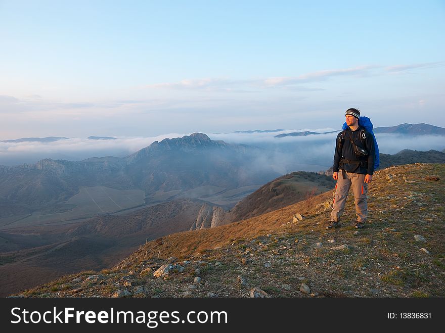 Hiker on a peak enjoys mountain landscape