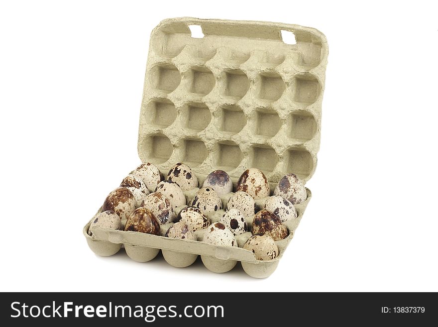 Quail eggs in a box on a white background