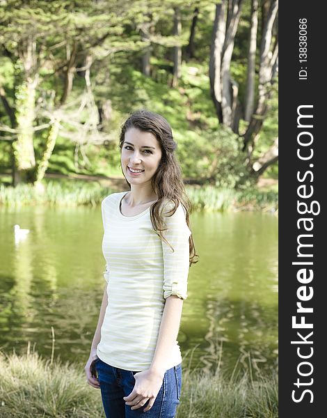Portrait of a Pretty Young Woman Standing in a Park. Portrait of a Pretty Young Woman Standing in a Park