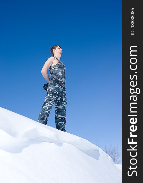 Man in camouflage clothing on the edge of the cliff