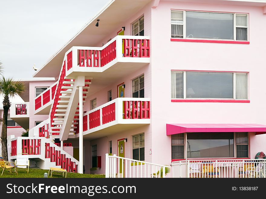 Pink colored motel with red stairs and balconies. Pink colored motel with red stairs and balconies