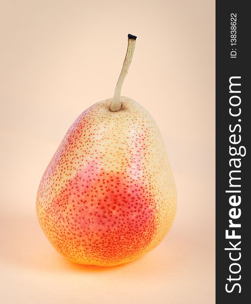 Tasty ripe pear on a beige background