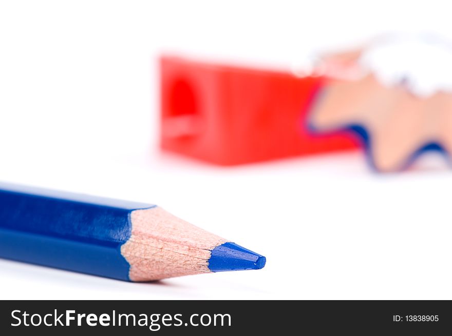 Blue pencil, red sharpener and wood shavings on white background