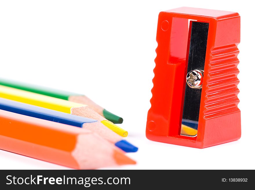 Colorful pencil and red sharpener on white background