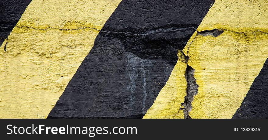 Yellow and black old emergency lines on concrete wall