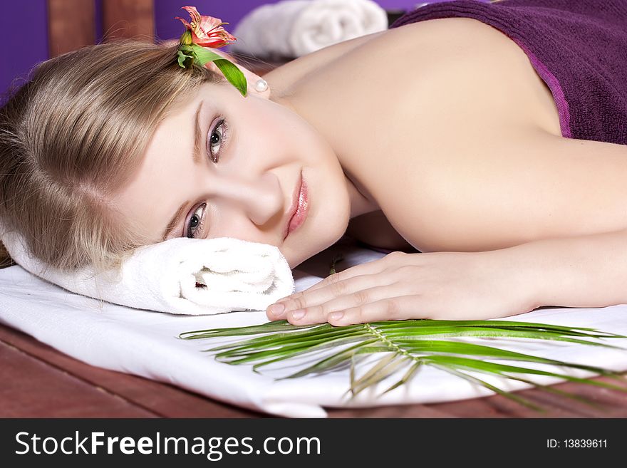 Beautiful woman on massage table with flower in hair. Beautiful woman on massage table with flower in hair