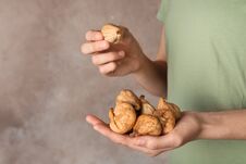 Woman Holding Handful Of Dried Figs On Color Background, Space For Text. Stock Photos