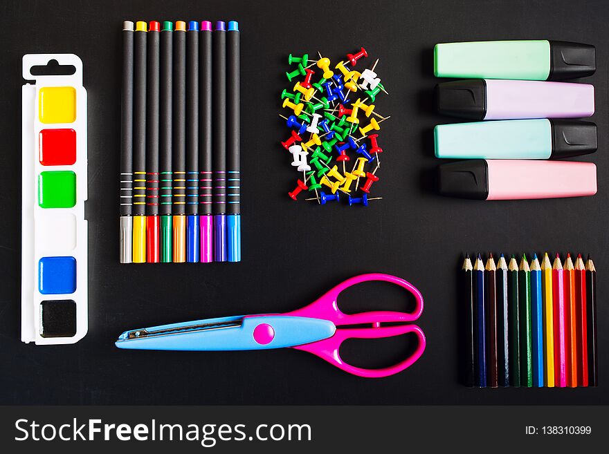 Different school accessories over blackboard background