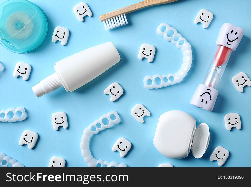Flat lay composition with small plastic teeth and dental care items