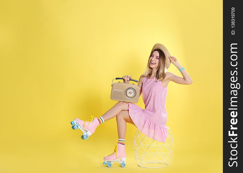 Young woman with roller skates and retro radio on color background, space for text