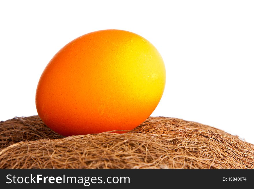 Orange egg on a straw closeup. Orange egg on a straw closeup