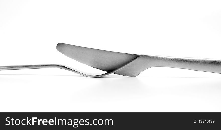 Knife resting between the teeth of the fork. Knife resting between the teeth of the fork