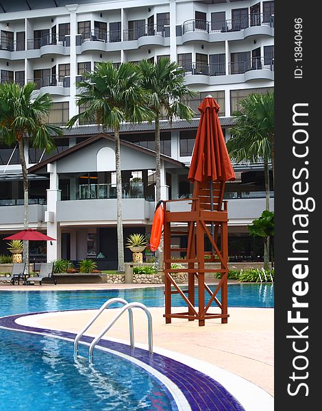 An image showing a lifeguard chair at a poolside of a luxury hotel. An image showing a lifeguard chair at a poolside of a luxury hotel