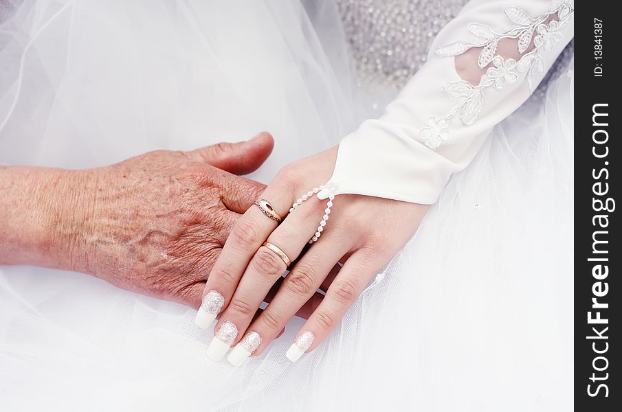 Hand in hand bride and old woman