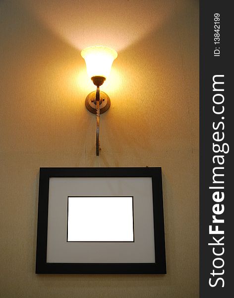 Photo of picture frame hanged under wall lamp. Photo of picture frame hanged under wall lamp