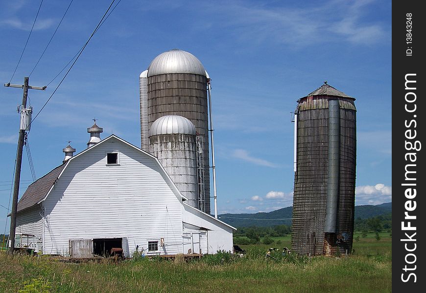 Large barn with three silos in Vermont with the mountains in the background. Large barn with three silos in Vermont with the mountains in the background.