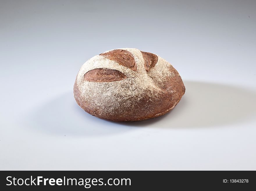 Loaf of bread with grains on a white background