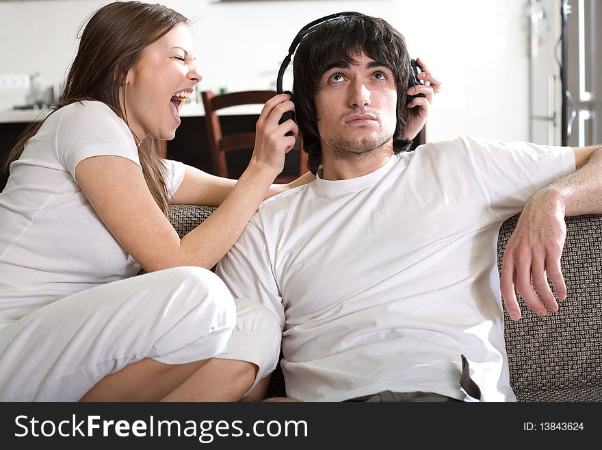 Boy in headphones with girl on sofa